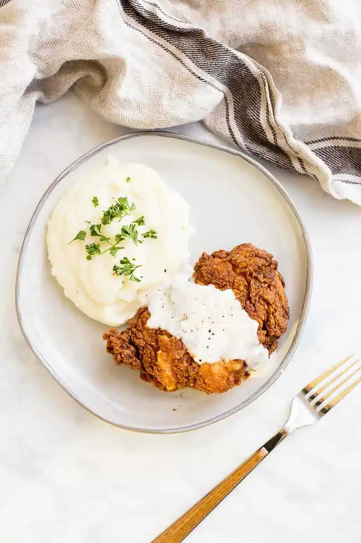 Overhead shot of Chicken Fried Chicken smothered with country gravy
